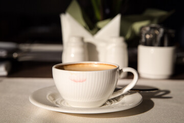 on the table in a restaurant, a white tablecloth. A cup of espresso coffee on a white tablecloth