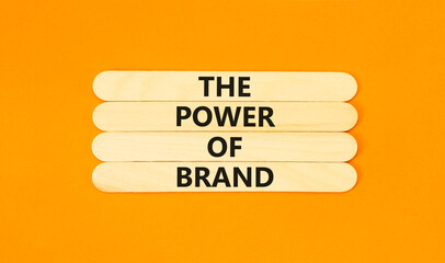 The power of brand symbol. Concept words The power of brand on wooden stick. Beautiful orange table...