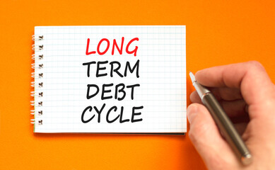 Long term debt cycle symbol. Concept words Long term debt cycle on beautiful white note. Beautiful orange background. Businessman hand. Business Long term debt cycle concept. Copy space.