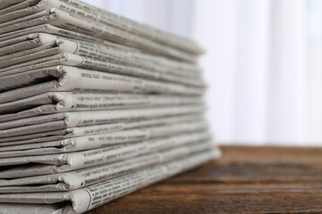 Stack of newspapers on wooden table, closeup. Journalist's work