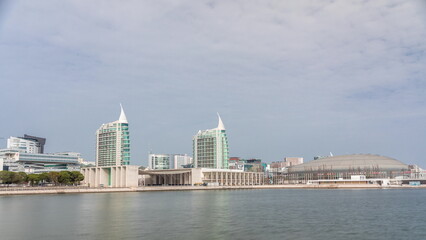 Naklejka premium Modern tall residential and office buildings reflecting in the water timelapse hyperlapse in Lisbon, Portugal.