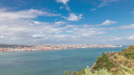 Fototapeta na wymiar Panorama showing Lisbon cityscape and Tagus river timelapse with 25 of April bridge