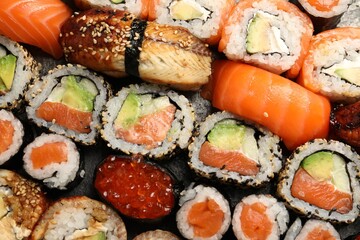 Different tasty sushi rolls as background, top view
