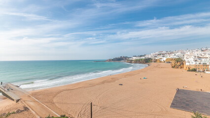 Wide sandy beach and Atlantic ocean in city of Albufeira timelapse. Algarve, Portugal
