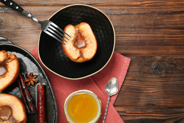 Tasty baked quinces served with honey on wooden table, flat lay. Space for text