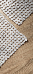 Detail of a grandmother's crocheted doily on a table. Vertical fabric brackground.