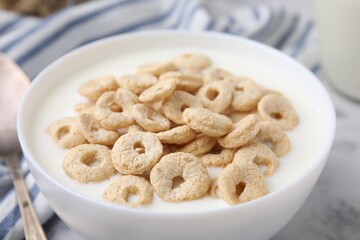 Breakfast cereal. Tasty corn rings with milk in bowl on table, closeup