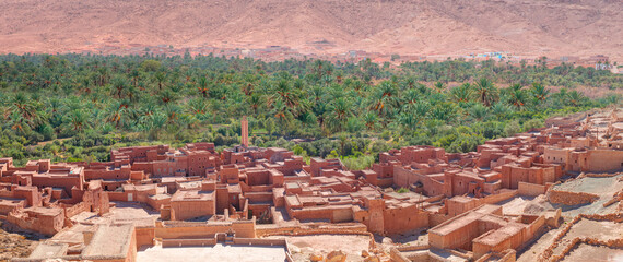 Old kasbah in Tinerhir, typical Moroccan town beside an oasis in Dades Valley - Ancient Berber village, lush green oasis in valley surrounded by the Atlas - Mountains - Tinghir, Morocco - obrazy, fototapety, plakaty