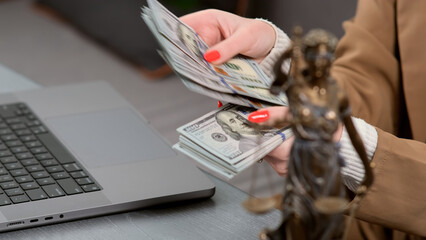 Close-up of a female lawyer at her workplace counting money. Concept of corruption, bankruptcy...