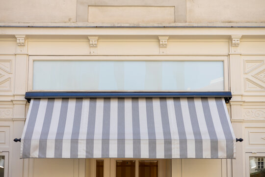 Gray and white awning over the windows on the white wall