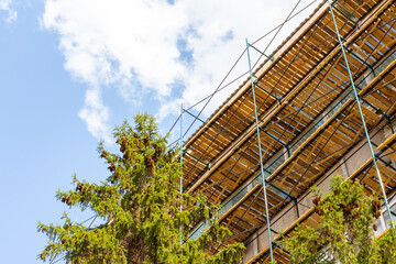 Low angle view of extensive wooden scaffolding on building during reconstruction. Copy space for your text. Soft focus. Construction site background theme.