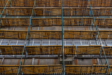 Low angle view of extensive wooden scaffolding on building during reconstruction. Copy space for your text. Soft focus. Construction site background theme.