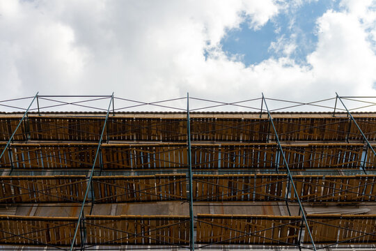 Low angle view of extensive wooden scaffolding on building during reconstruction. Copy space for your text. Soft focus. Construction site background theme.