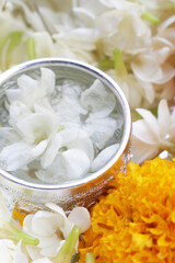 Obraz na płótnie Canvas Water with jasmine flower and marigold. Thai tradition, Songkran festival concept