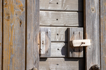 
A wall of wooden planks with a wooden handle for closing the door