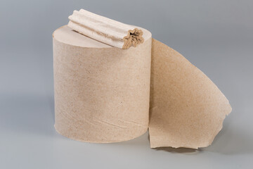 Leftover toilet paper lies on whole roll on gray surface