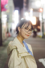 Portrait of japanese young woman in tokyo night city background with neon light bokeh