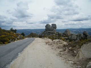 Uma estrada na montanha de Serra do Alvão, Portugal, com pedras grandes ao lado