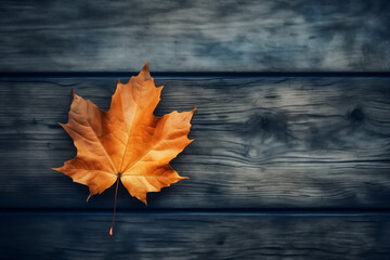 Yellow autumn leaf on wooden background. Top view, copy space.