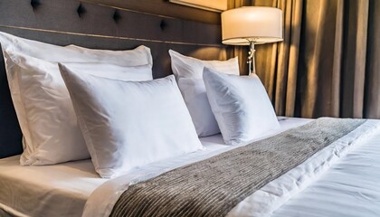 close up on minimalistic hotel bedding clean white pillows duvets bedsheets neatly placed on a bed