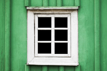 Fototapeta na wymiar Rustic window in wooden village cottage house. Green wood wall. Countryside architecture background. Small window frame white paint. Empty copy space interior. Square shape window.