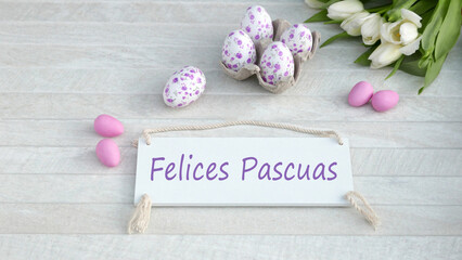 El texto Felices Pascuas escrito en un cartel con decoraciones de Pascua.