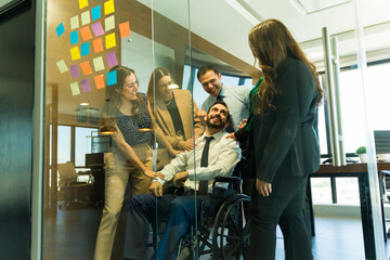 Group of people recognizing a disabled person's work in an inclusive office
