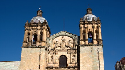 Fototapeta na wymiar Front facade with bell towers on the Church and Convent of Santo Domingo de Guzman in Oaxaca, Mexico