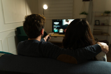 Boyriend and girlfriend watching a movie on a streaming service