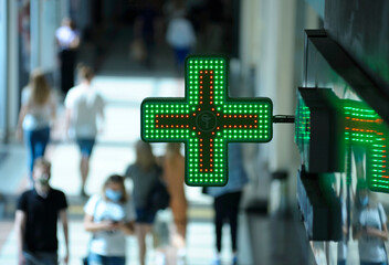 Pharmacy green cross and medicine symbol a vessel with a snake set over entrance of a drugstore,...
