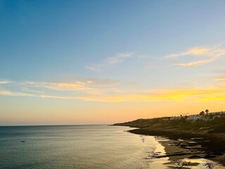 Orange sunset at the ocean, rocky ocean bay