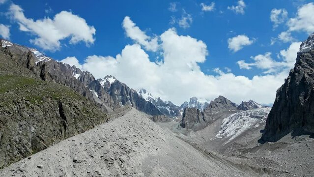 Amazing mountain landscape, summer natural scenery, snow capped peaks highlands, blue sky with clouds. Ala Archa national park, Kyrgyzstan. Travel destination, climber place. Aerial drone 4k footage