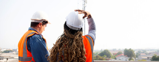 Team young engineer man and woman examining and checking station telecommunication at construction site, architect or inspector planning maintenance telecom tower, industry concept.