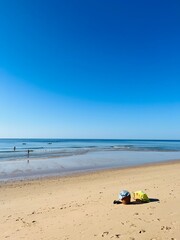 Fototapeta na wymiar Sandy ocean beach, shoreline, clear blue sky, blue seascape horizon 