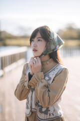 Portrait of a stylish Asian woman enjoying a vacation in Japan. A cheerful and attractive model in her 20s amidst nature's beauty, with a sunny and refreshing vibe.