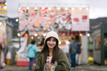 Japanese traveler enjoys a tasty strawberry treat in Tokyo during the sakura festival. A happy...