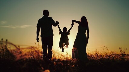 Man and wife take girl to field to practice family yoga. Man with beloved wife walking in fresh evening air of park with little daughter. Man with wife and daughter finally gets out for walk