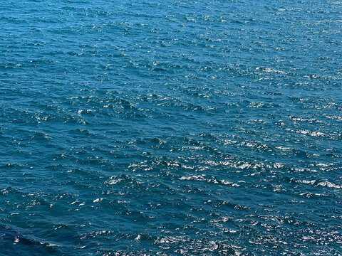 Blue sea water glittering calm surface. 