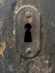 Close up of old keyhole on antique wooden door