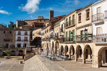 Noble houses with stone arches and balconies next to the main square of Trujillo, Spain.