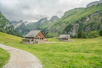 Fototapeta na wymiar Hikinig trail towards Seealpsee, an alpine lake in Appenzell Alps in Switzerland. small mountain hut in the Swiss Alps. Beautiful hiking area. Appenzell mountains.