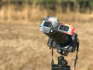A special protected professional camera looking at the sun during a solar eclipse on a country park - 750034765