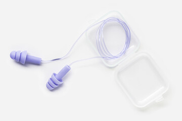 Reusable silicone earplugs purple color in box, for swim, sleep, rest. Soft, flexible ear plug on string against noise, protect hear, close up object on white background, top view, flat lay