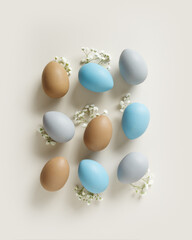 Easter Aesthetic with Matte Eggs and Delicate Florals, painted chicken egg decorated white flowers, top view on beige background, spring holiday concept. Minimal style pattern in pastel tones