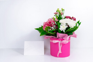 Big beautiful bouquet of  various natural flowers in a pink gift box. White background. Greeting card for birthday, mother's day, women's day or other occasion. Copy space.