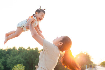 Mother and child playing in the park,Beautiful Asian mother and child play happily in outdoor...