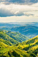 Verdant slopes of Monteverde under a dynamic sky, showcasing the rich biodiversity and layered mountain vistas of Puntarenas Province, Costa Rica. High quality photo.