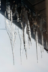 icicles above the entrance. Dangling icicles put pedestrians in danger. - 750053341