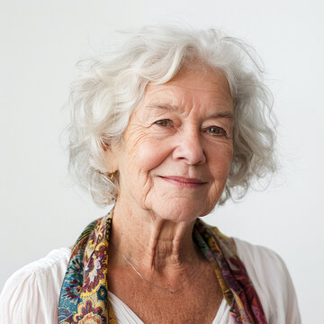 Portrait of a senior woman with a white studio background. Warm, friendly, and wise facial expression