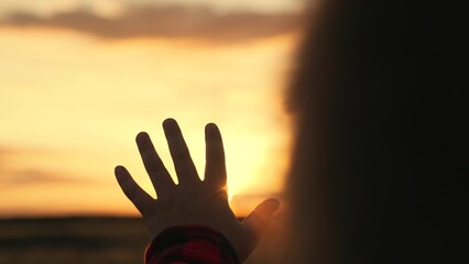 Children prayer. Boy stretches his hand to beautiful sky, dreams in nature. Hand of child boy...